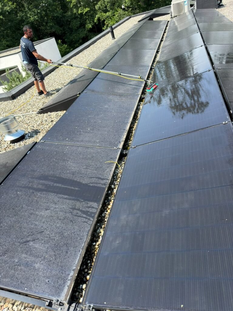 Technicien nettoyant une installation photovoltaïque en toiture