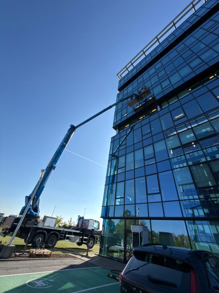 Nettoyage de la façade vitrée d'un bâtiment moderne à la nacelle