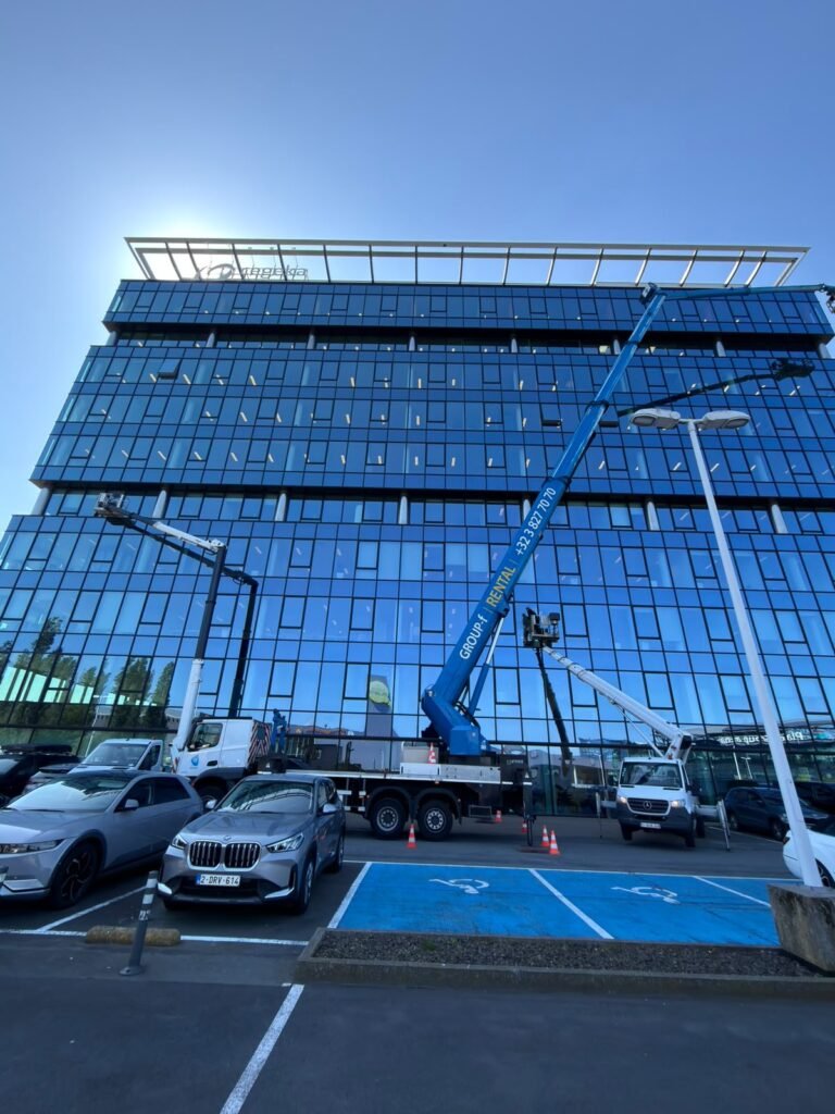 Nacelle élévatrice en cours de nettoyage de vitres sur la façade d'un immeuble de bureaux